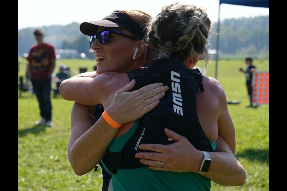 Solo competitors Kyley Feculak and Kim Watt share an embrace Sept 9. after finishing the 24.5 kilometre sprint with the fastest times in the women’s division.  Photos by Lexi Freehill/AA