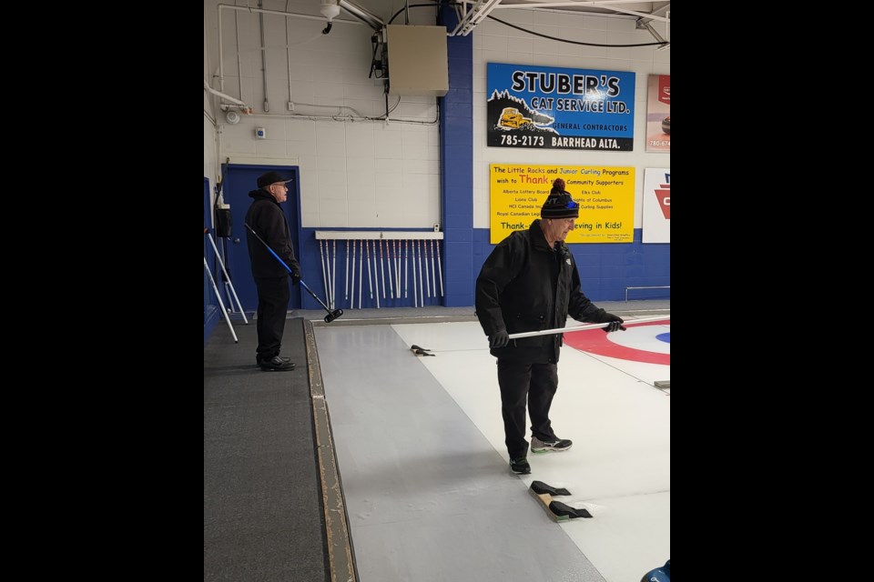  Ron Busch (L) watches the play at the other end, his partner Irvine Reidford,  while Vern Kalbach(R) monitors the progress of an incoming rock, his partner Keith Senneker on Feb. 18 at the Barrhead Curling Rink.