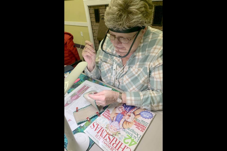 Jennifer Rhodes works on a Christmas ornament cross-stitch project for the 2023 holiday.