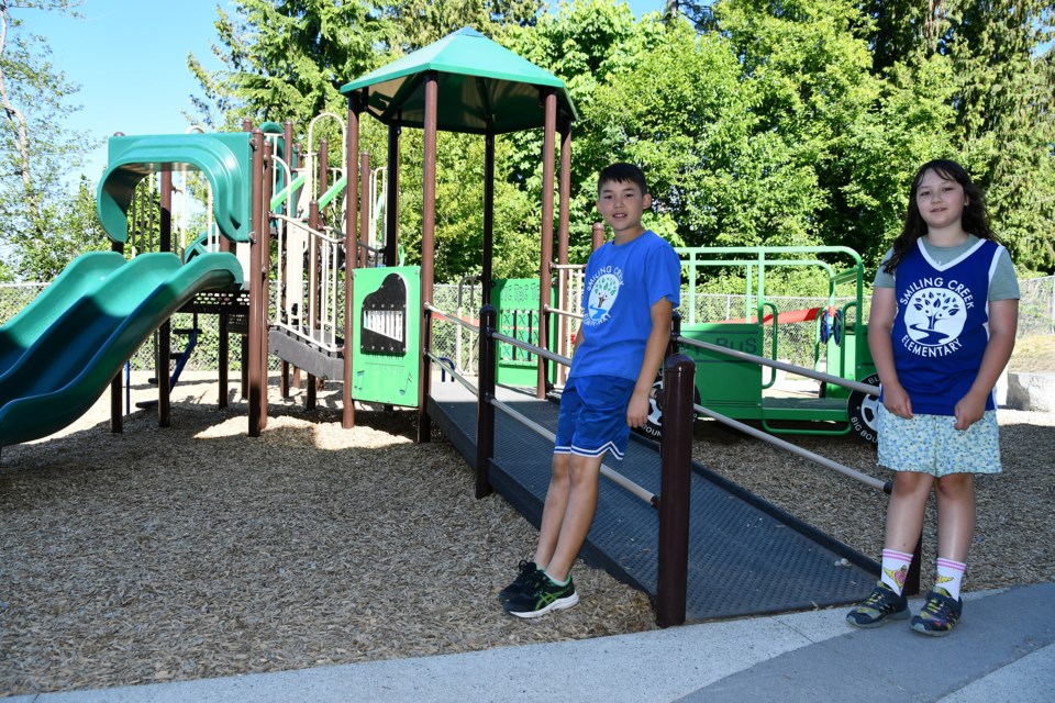 Matthew Denney, Grade 5, and Mikaela Toporowski, Grade 4, check out the new wheelchair-accessible playground at their school: Smiling Creek Elementary on Burke Mountain.