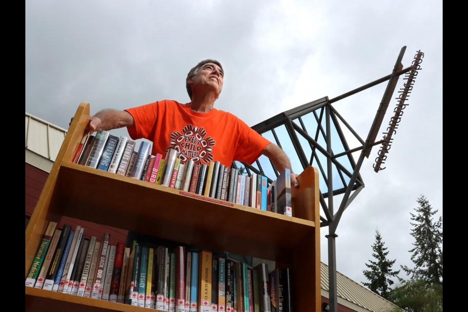 Coquitlam writer Alf Dumont, with some of his donated books at the Poirier library branch.