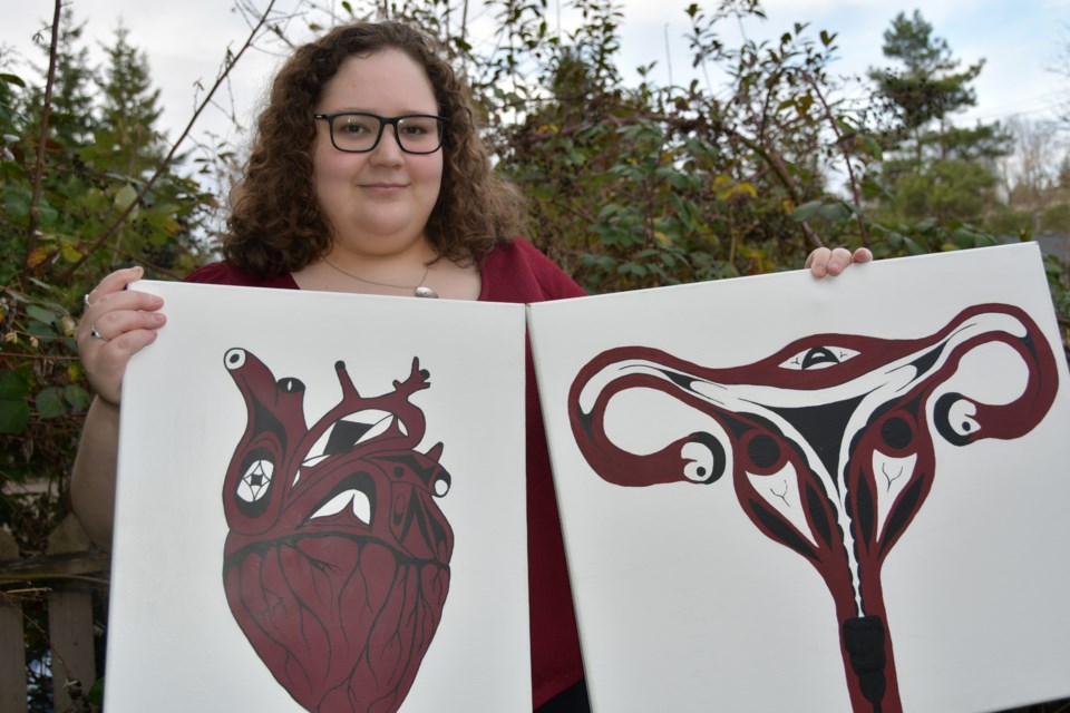 Coquitlam artist Ashley Jones with her "Heart of a Nation" and ovaries paintings.