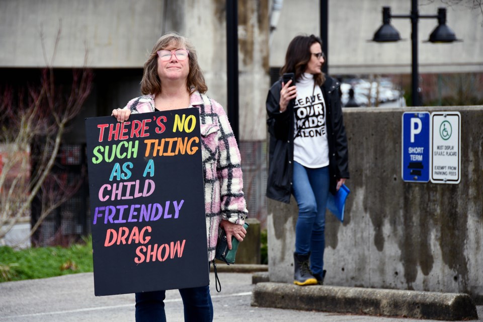 "Cheryl" holds a sign in front of the reception area for the drag story time at the Evergreen Cultural Centre on March 28, 2024.