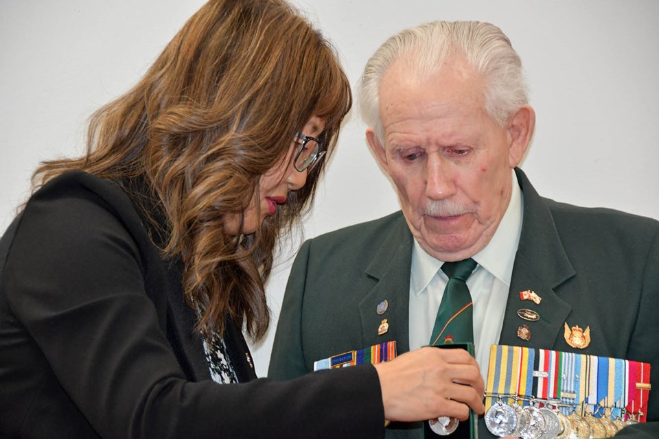 Leo Valentine checks out the King Charles III Coronation Medal with Senator Yonah Martin at the Coquitlam Legion on March 28, 2025.