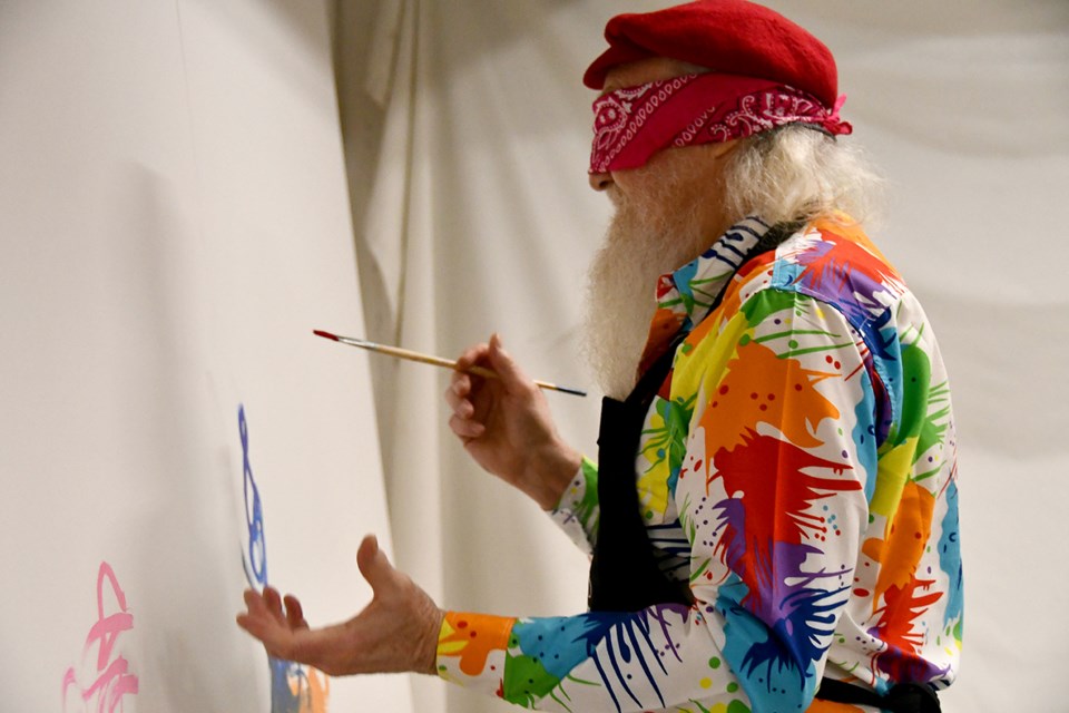 A man tries out painting while blindfolded at PoMoArts' birthday for ART on Jan. 24, 2024.