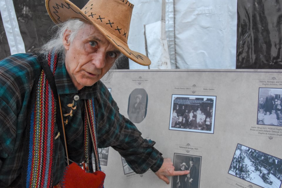 Roger Loubert at the 2019 Festival du Bois celebrations, pointing to photos of Maillardville pioneers.