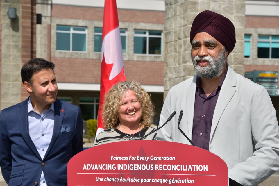 Attorney General Arif Virani and First Nations educator Marny Point look on as Harjit Sajjan speaks at Douglas College in Coquitlam after a campus tour on April 23, 2024.