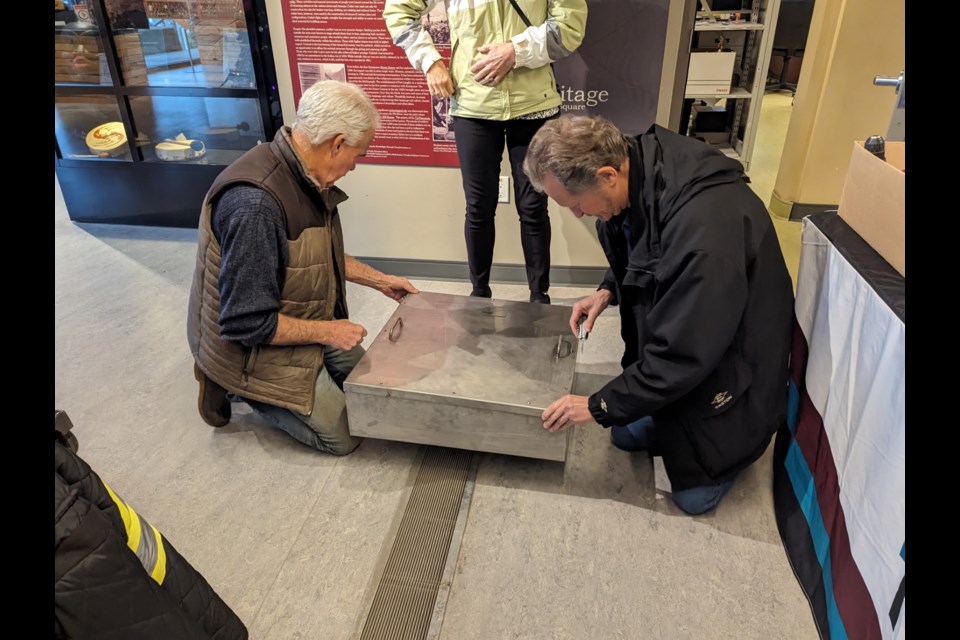 Former city councillor Mike Forrest (left) helps to seal the time capsule.