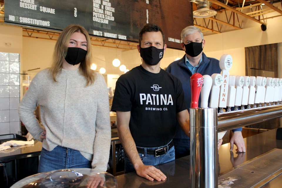 The Tri-CIties Chamber of Commerce’s Stephanie Rennie and Michael Hind flank Kyle O’Genski, the CEO and a co-owner of Patina Brewing Co. — one of the 50 eateries taking part in the inaugural Taste of the Tri-Cities, from Feb. 15 to March 19.