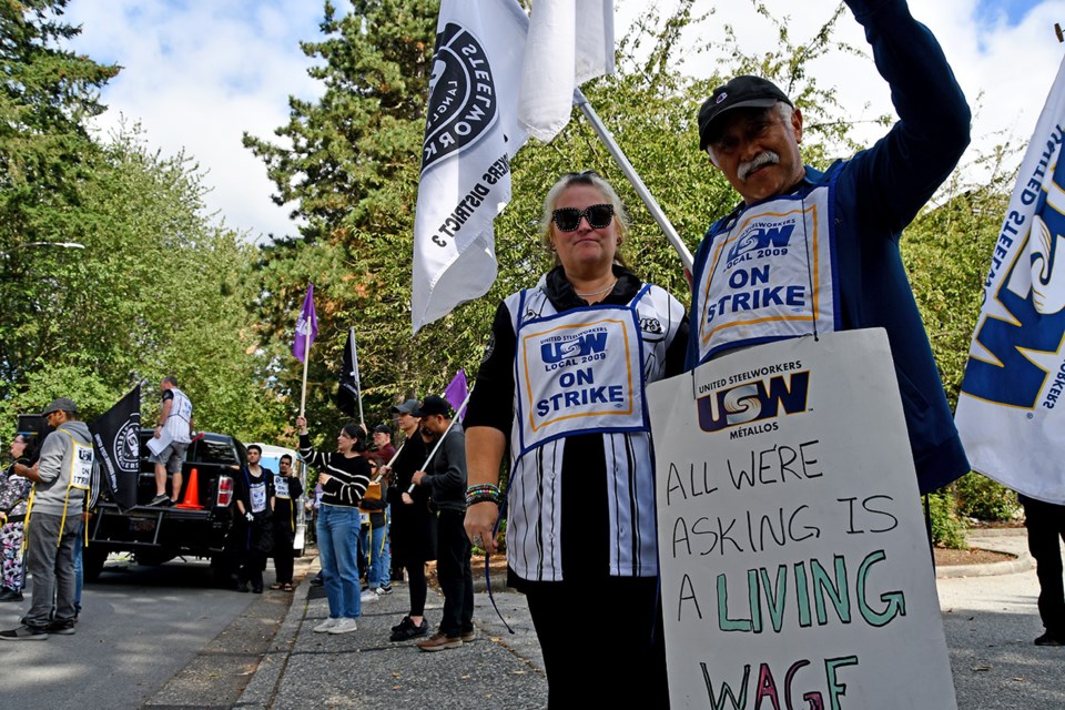 Melissa Zakus and Jesus Ramos strike outside their company, Uni-Select, Bumper to Bumper, during a lunchtime rally on Sept. 18, 2024.