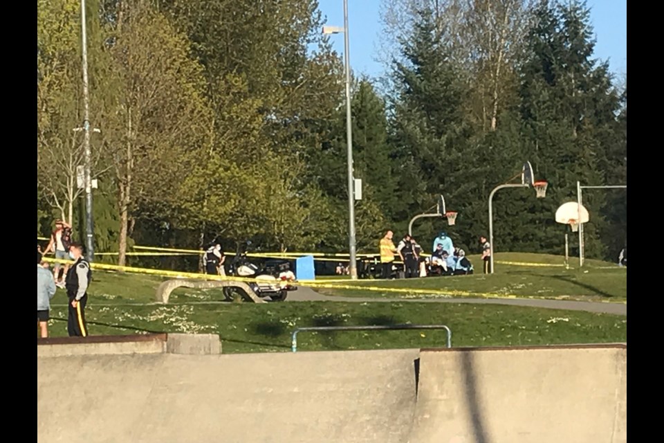 First responders work on the victim of an apparent shooting at the basketball courts at Coquitlam's Town Centre Park Monday evening.