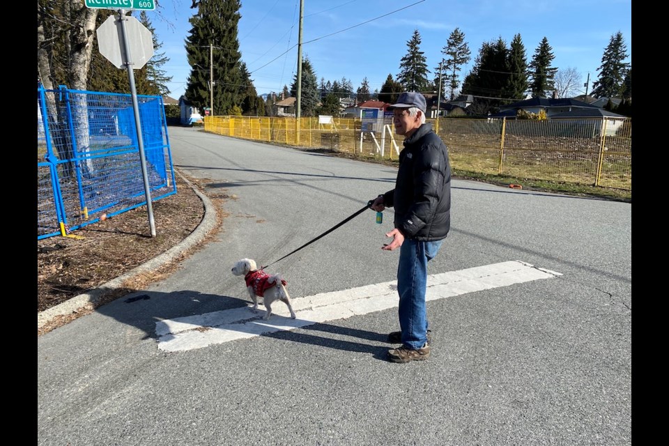 A man walks his dog amidst land development in Oakdale in Coquitlam.