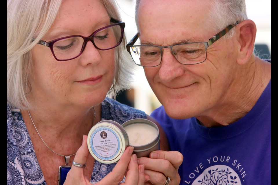 Tim and Lisa Ferguson take in the scent of one of the balms and soaps they concoct in the kitchen of their Port Moody home and sell at farmer's markets in their hometown as well as Coquitlam and Burnaby.