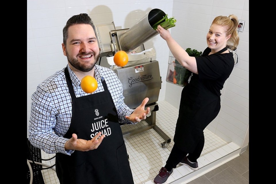 Callan and Jessica Morrison squeeze oranges in a commercial presser installed in a custom shower stall at the back of their original Port Coquitlam shop.