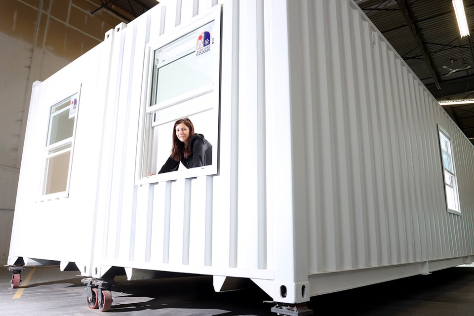 Homeira Raviz looks out from one of the shipping container homes her company, Archimax, is building in its Coqutilam warehouse for deployment to remote First Nations, as transitional and student housing or to resorts and work camps for employees.