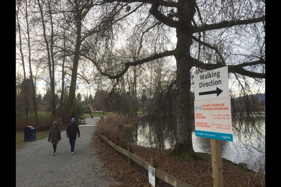 Walkers heed directional signs at Como Lake Park in Coquitlam. Vandals have been destroying signs in three Coquitlam parks forcing city workers to replace them.
