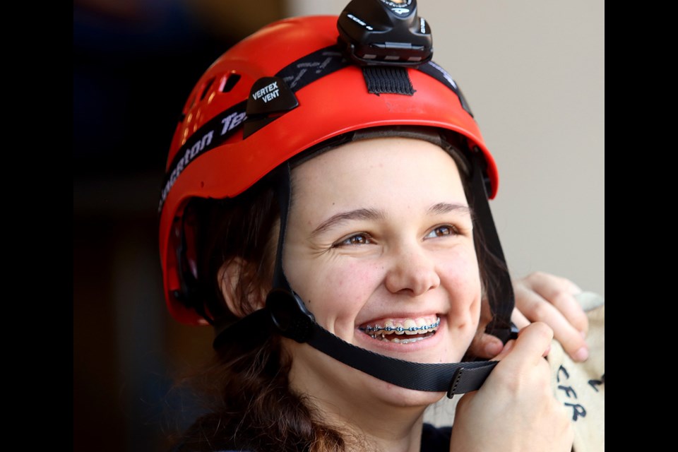 Liv Letourneau secures her helmet prior to high-angle rescue training at Coquitlam Fire and Rescue's annual Jr. Firefighters camp.