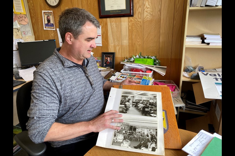 École Irvine Elementary school principal Dennis Shannon with a scrap book of memories.