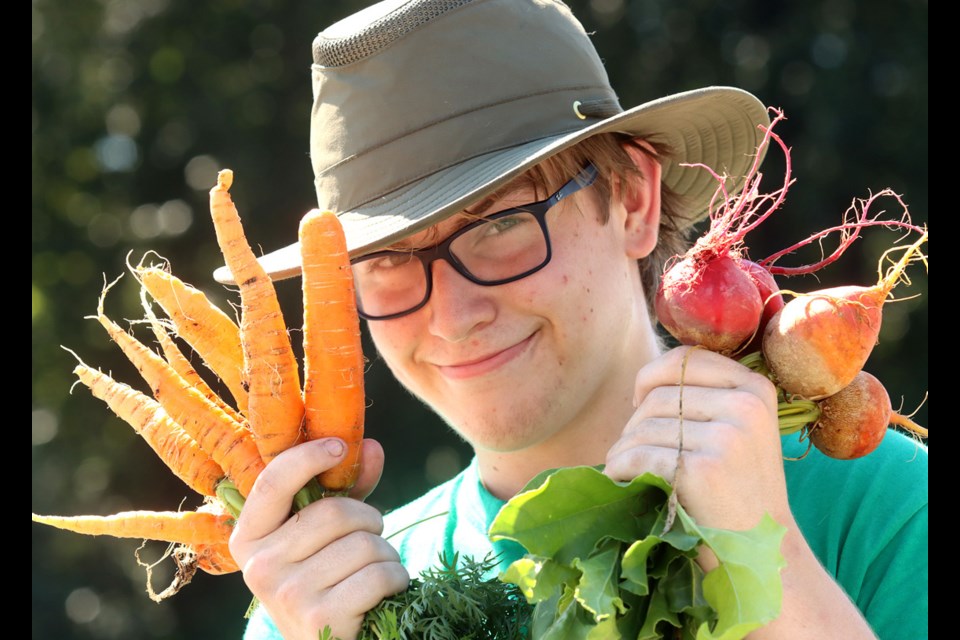 Showing off a colourful carrot and beet crop is Jack Elliot, a Coquitlam student selling veggies at a Fresh Roots pop up stand.