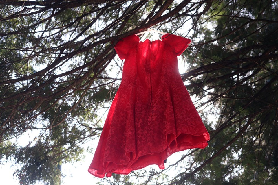 Students at Dr. Charles Best Secondary hung red dresses on trees along Coquitlam's Como Lake Avenue on May 2, 2023, as a sign of solidarity for Missing and Murdered Indigenous Women, Girls and Two-Spirit people (MMIWG2S).