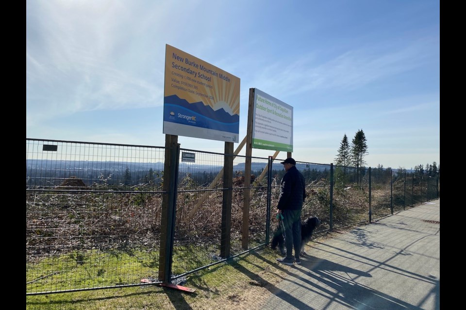 Signs up at the Burke Mountain high school and park project in Coquitlam, where trees were recently cut down.