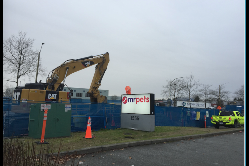 A sign for Mr. Pets (as seen frm the parking lot) is hidden from the road by construction hoarding for the Trans Mountain pipeline dig.