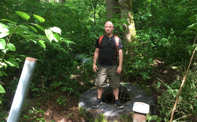 Carl Ronka stands on one of several large truck tires dumped at the Coquitlam River.