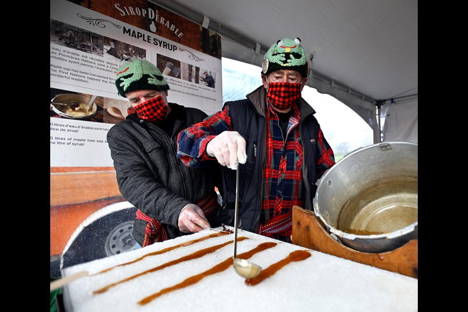 Roland Therien pours boiled maple syrup onto snow at Festival du Bois. 



