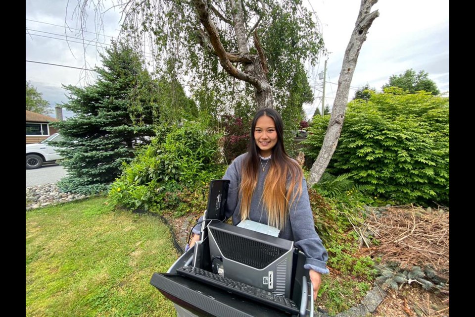 Coquitlam student Janielle Domingo holds a recycling bin full of electronics ahead of hosting and managing a series of E-waste Collection Events in the Tri-Cities.