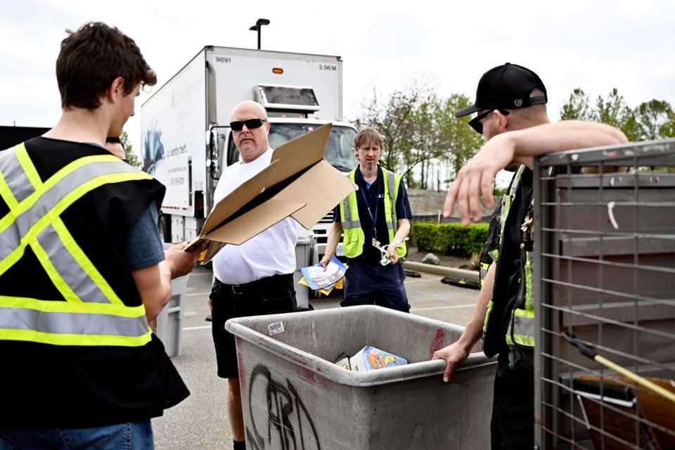 Volunteers with the Port Coquitlam Community Foundation and the Elevator Constructors local 82 shred documents outside of Canadian Tire in Port Coquitlam on April 20, 2024. 