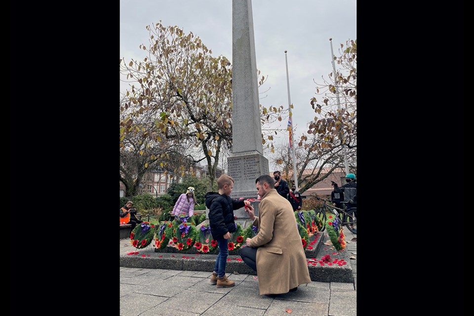 Port Coquitlam Mayor Brad West lays a wreath on behalf of city council, as well as a poppy with his son, at the cenotaph for Remembrance Day 2021.