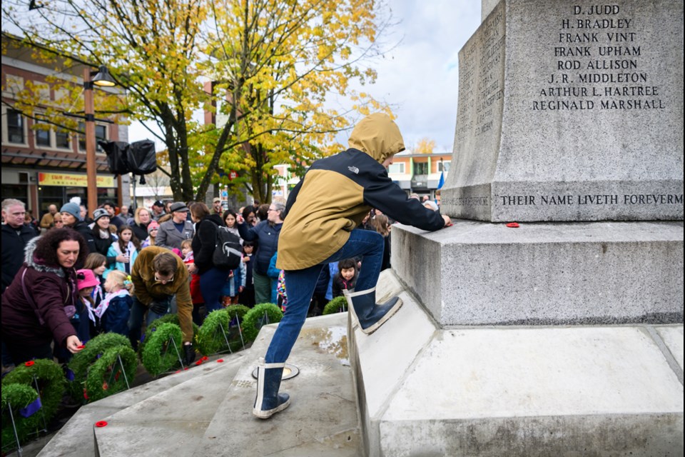 Edward Douglas Galer places a poppy on the cenotaph that bears the name of his great grand uncle, Douglas Davison.