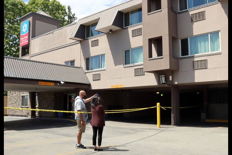 Staff survey the damage to the Sure Stay hotel on Brunette Avenue in Coquitlam after a fire Wednesday destroyed at least one room.