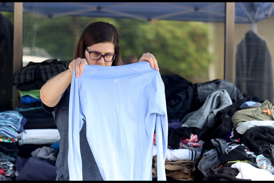 Leigh-Ann Goertzen sorts through clothing at a special garage sale on July 6, 2022, to help victims of a fire in June that displaced residents of a Port Coquitlam condo building. | Mario Bartel, Tri-City News