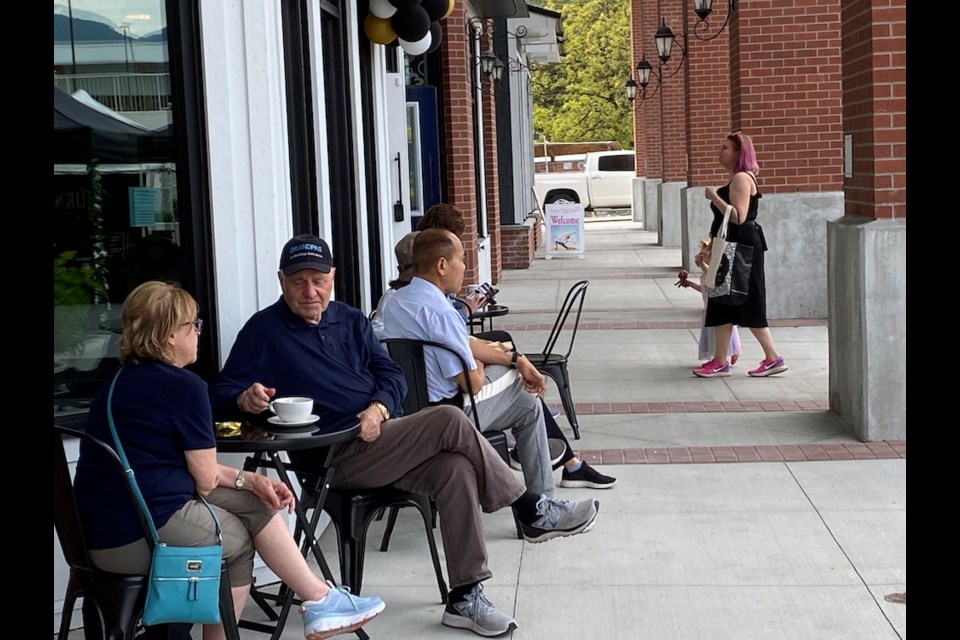 Customers enjoy a coffee and gluten-free pastry outside Caffé Delish in Montrose Square in Port Coquitlam.