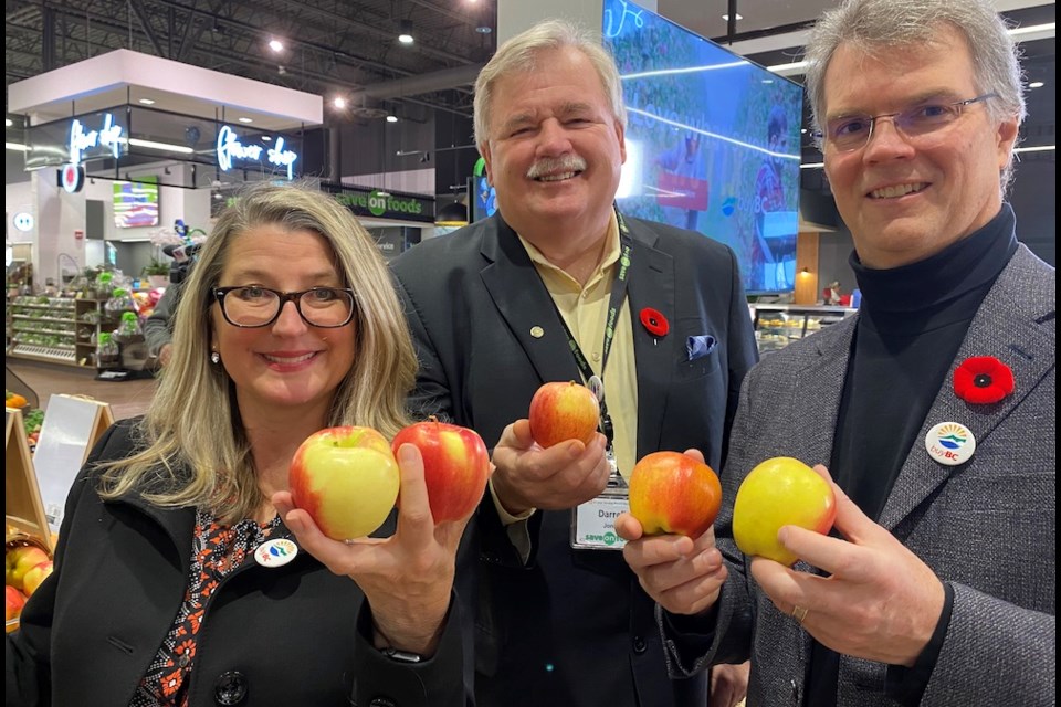 Lana Popham, B.C. minister of agriculture, Darell Jones, president of Save-On-Foods and Fin Donnelly, Coquitlam-Burke Mountain MLA, with apples from the Apple Cup display at the Coquitlam store.
