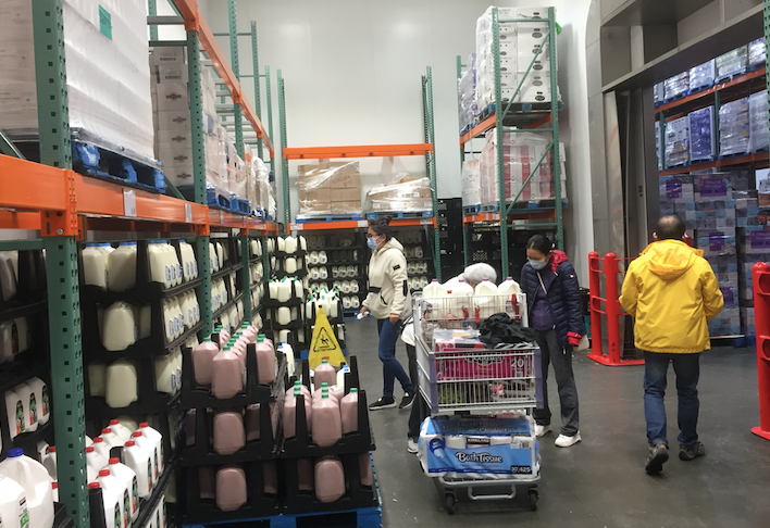 People shop for dairy at Costco, where customer limits were put in place.