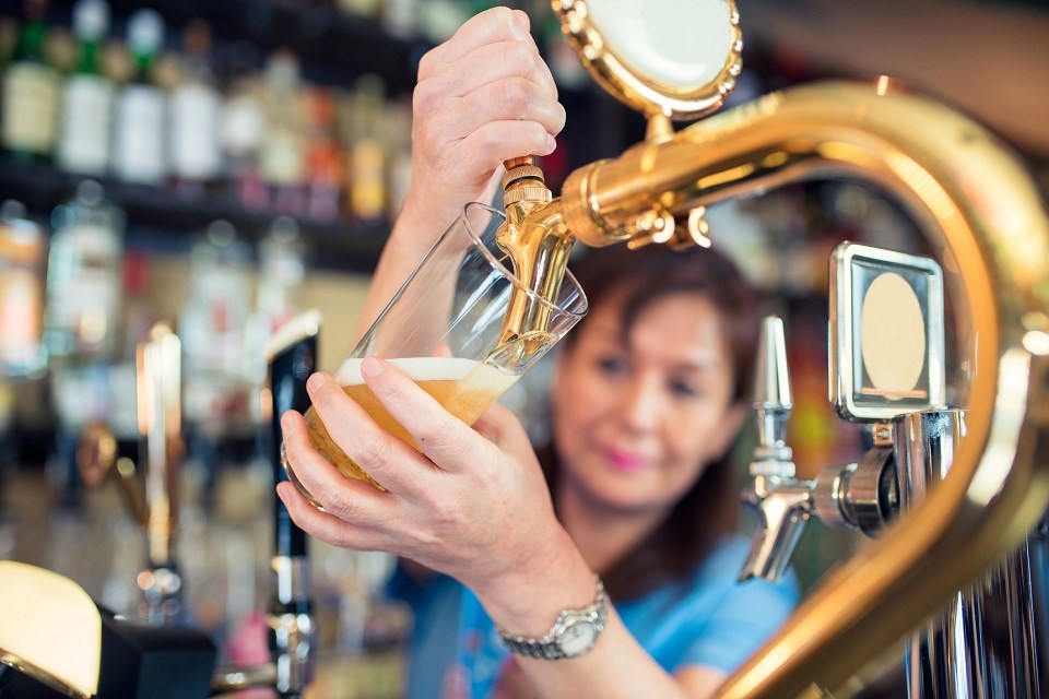 Woman pouring beer - Getty Images