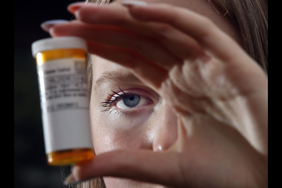 Chloe Goodison, an SFU student from Port Moody, examines a bottle of Naloxone.. She's prepared a program in conjunction with School District 43 to teach high school student to recognize the signs of an overdose and administer the antidote.