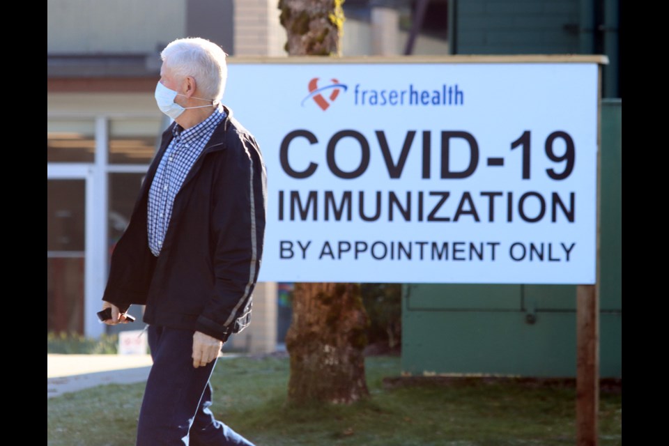 A successful COVID-19 vaccine recipient heads back to his vehicle from the new immunization centre at the Poirier Forum in Coquitlam that opened on Monday.