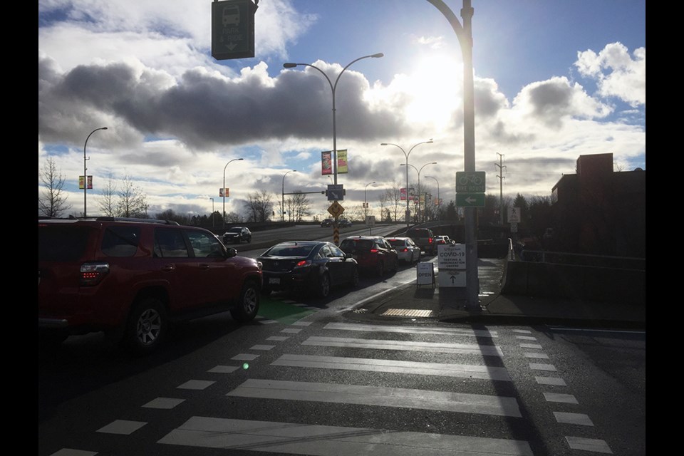 A line-up of vehicles begins to form off Mariner Way for the Coquitlam Central Station Park and Ride overflow lot as many look to get immunized with a vaccine against COVID-19 ahead of the holidays (Dec. 23, 2021).