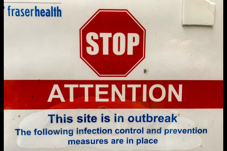 A sign stuck to the entrance at Lakeshore Care Centre in Coquitlam, B.C., indicates the site is under outbreak protocols.