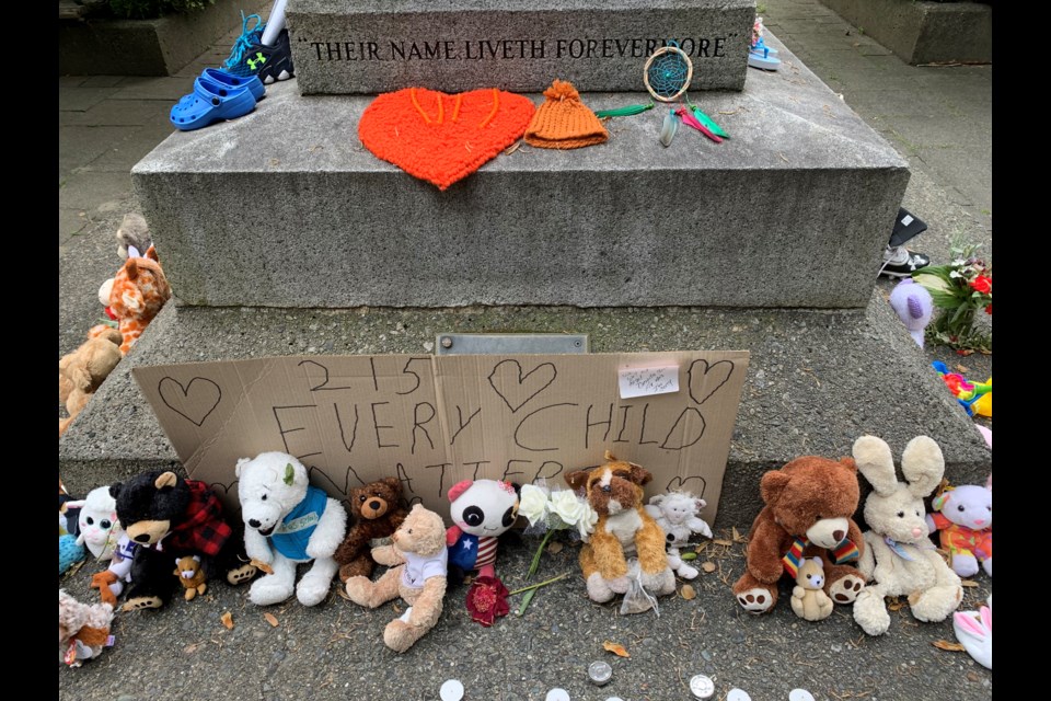 Tributes, including shoes and teddy bears, are being placed at the Port Coquitlam cenotaph in the wake of news that the bodies of 215 children have been discovered outside of a former Kamloops residential school.