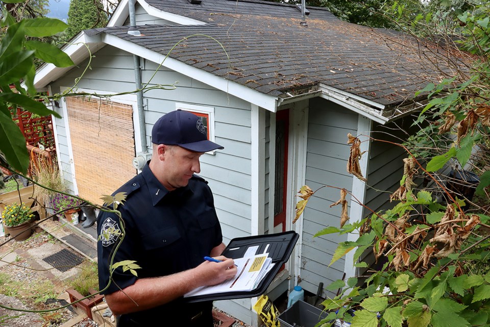 Port Moody firefighter Jeff Scallion does a FireSmart assessment on a home to determine measures to lessen its risk from wildfires. On of those is keeping a roof clear of dried debris like fallen leaves and dried needles.