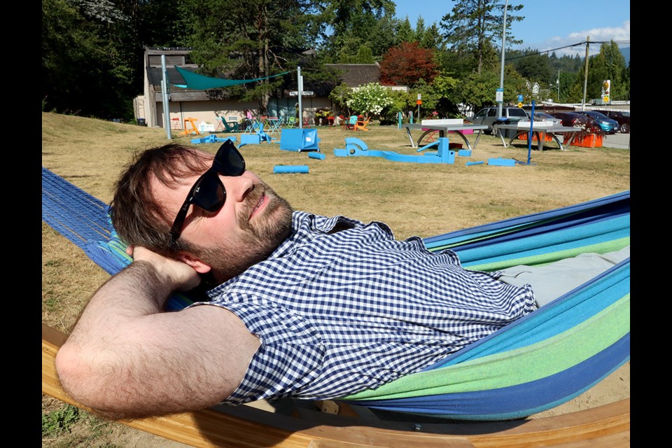 Port Moody's supervisor of parks, Robbie Nall, relaxes in one of the hammocks that's been added to the park next to Kyle Centre, as part of a pilot program to activate the otherwise barren patch of grass.
