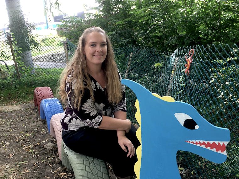 Port Moody Station Museum manager Brianne Egeto takes a seat on a colourful dragon in the new enchanted garden.