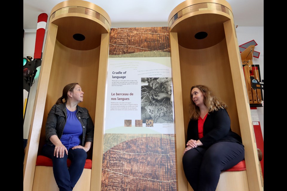 Brianne Egeto (right), the manager/curator of Port Moody Station Museum,  helps set up an exhibit about threatened Indigenous languages.