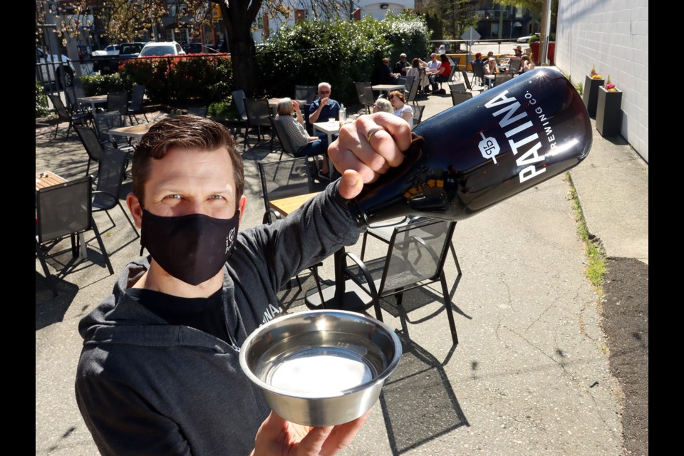 Kyle O'Genski serves up a doggie bowl of water for thirsty four-legged visitors to the patio of his Port Coquitlam brewery, Patina.