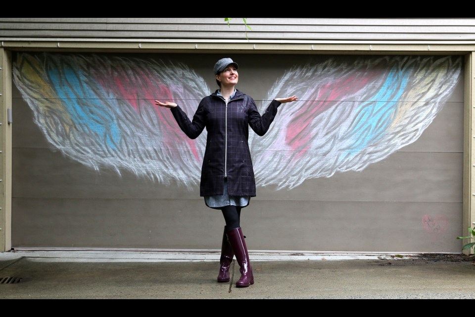 Ladawne Shelstad poses with one of her first "interactive" chalk murals she's created for garage doors in her Klahanie neighbourhood in Port Moody to help brighten spirit during the COVID-19 lockdown.