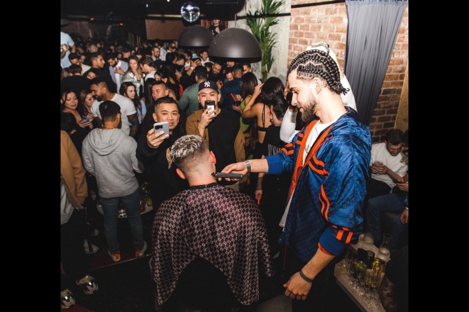 Justin Karbowiak, owner of Barber Dash, cuts hair at a night club.